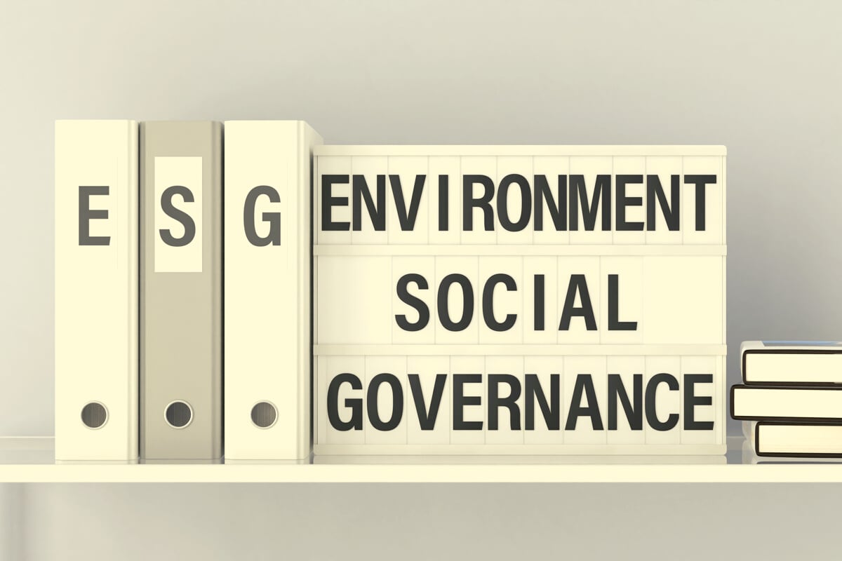 Lightbox displaying the text "Environment Social Governance" with three binders with the letters ESG on a shelf. ESG concept